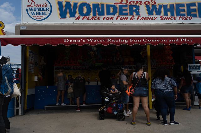 a family enjoys a game stand at Coney Island